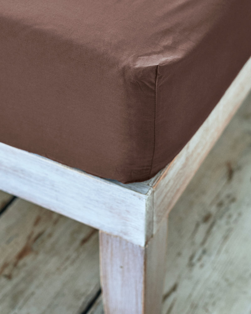 close up of the corner of acorn brown fitted sheet 