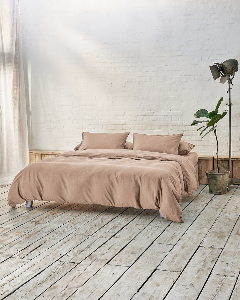 Industrial bedroom with beige bedding and wooden floors