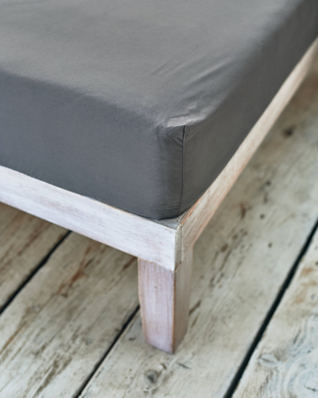 tight fitted corner of dark grey cotton bedsheet