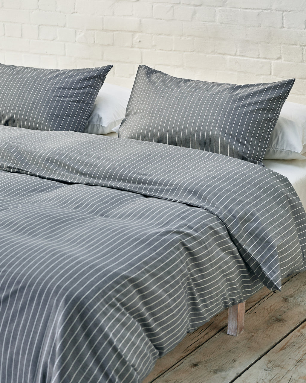 navy and white striped bedding set in an industrial bedroom