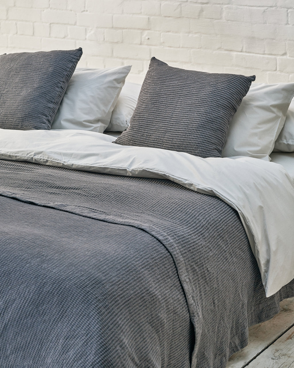 light grey luxury bedding set with dark grey waffle bedspread and scatter cushions
