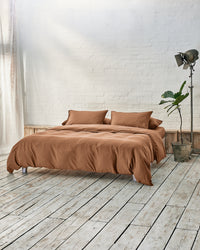 lifestyle image of caramel brown in a modern bedroom with rustic wood floors and white walls.