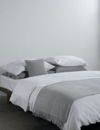 light grey alpaca wool throw on crisp white bedding. 