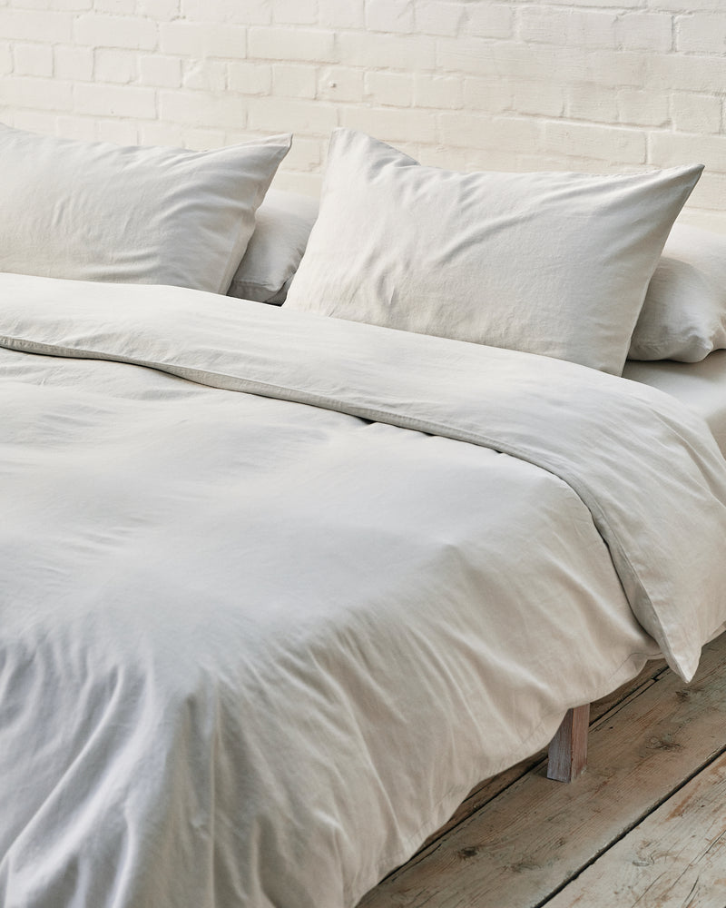 light grey bedding set in an industrial bedroom