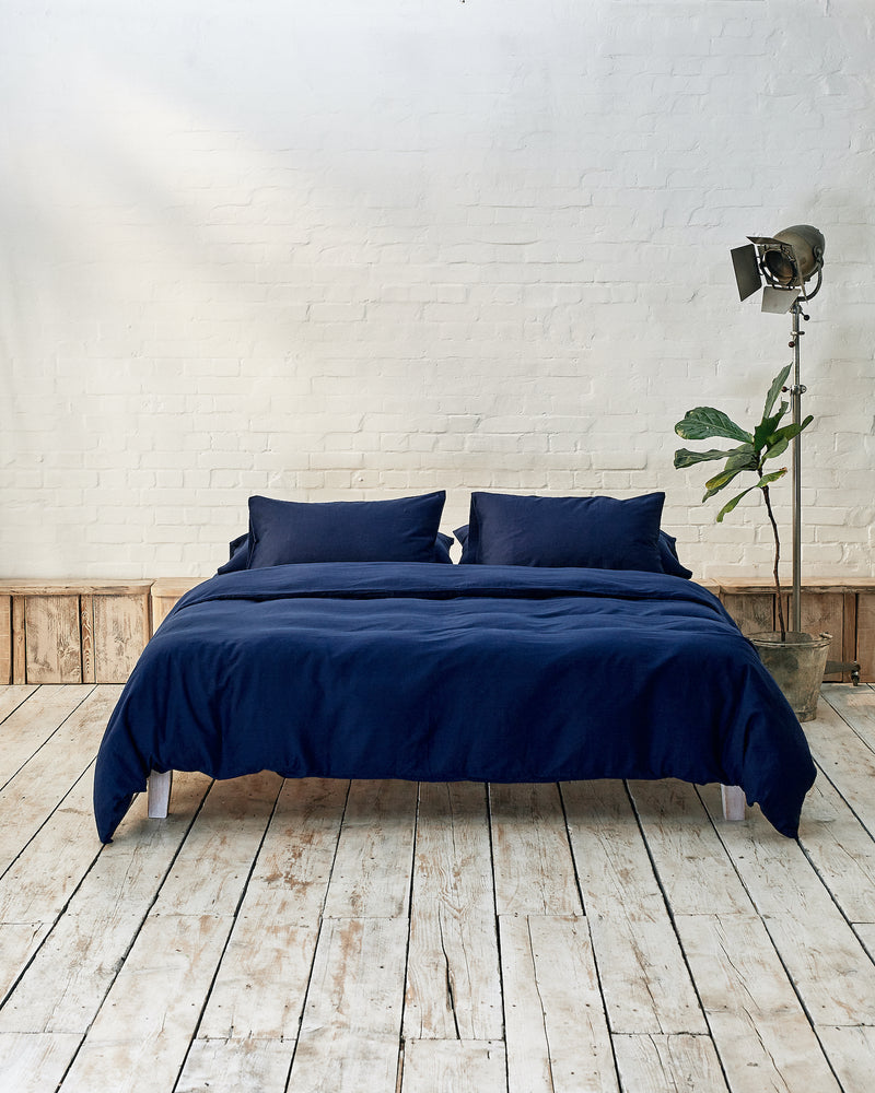 navy blue bedding set in an industrial bedroom